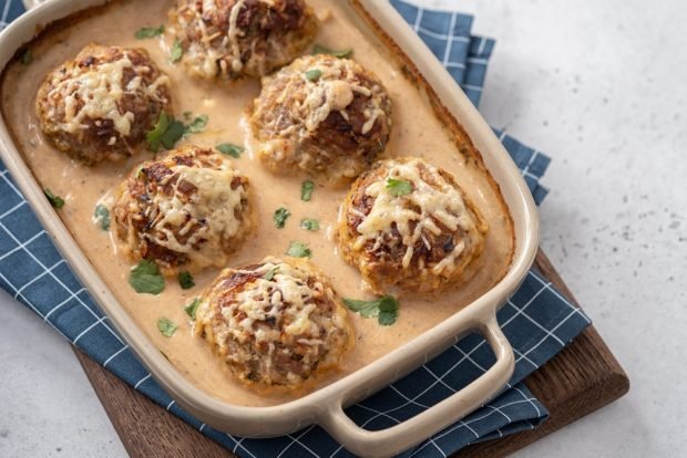 Baked meatballs with zucchini under cheese