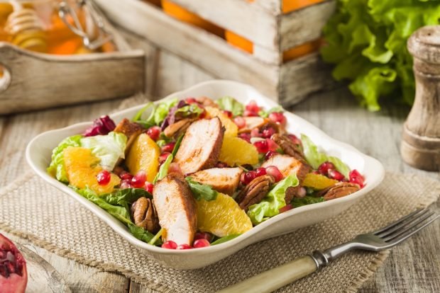 Salad with chicken, grenade, nuts and honey dressing