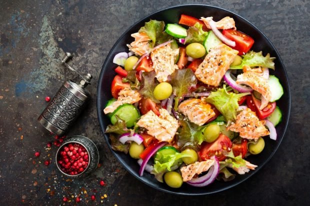 Vegetable salad with fried red fish and olives