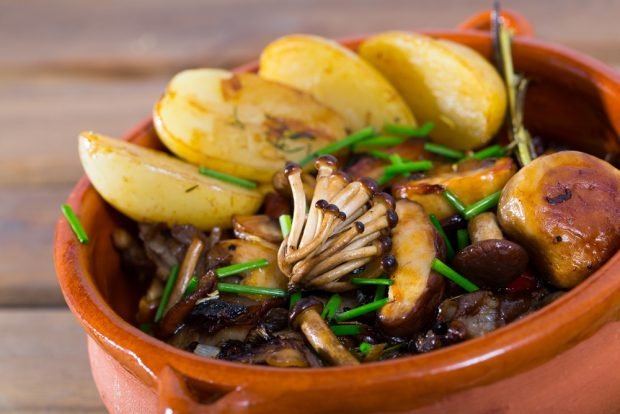Young potatoes with forest mushrooms in pots Young potatoes with forest mushrooms in pots
